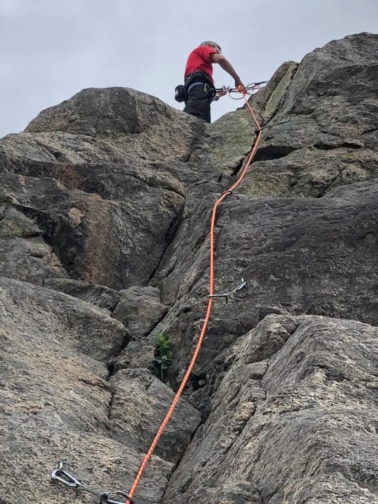 Klatrer i toppen av en rute på klatrefeltet Helleneset