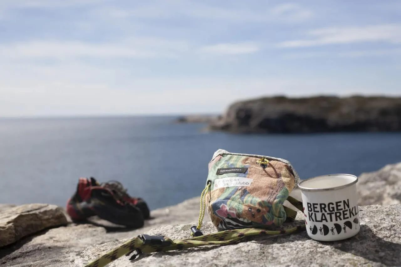 Klatresko og kalkpose på svaberg med sjø i bakgrunnen